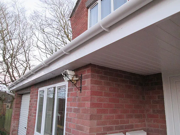 Roofline products: white fascia, soffit and guttering on a brick house